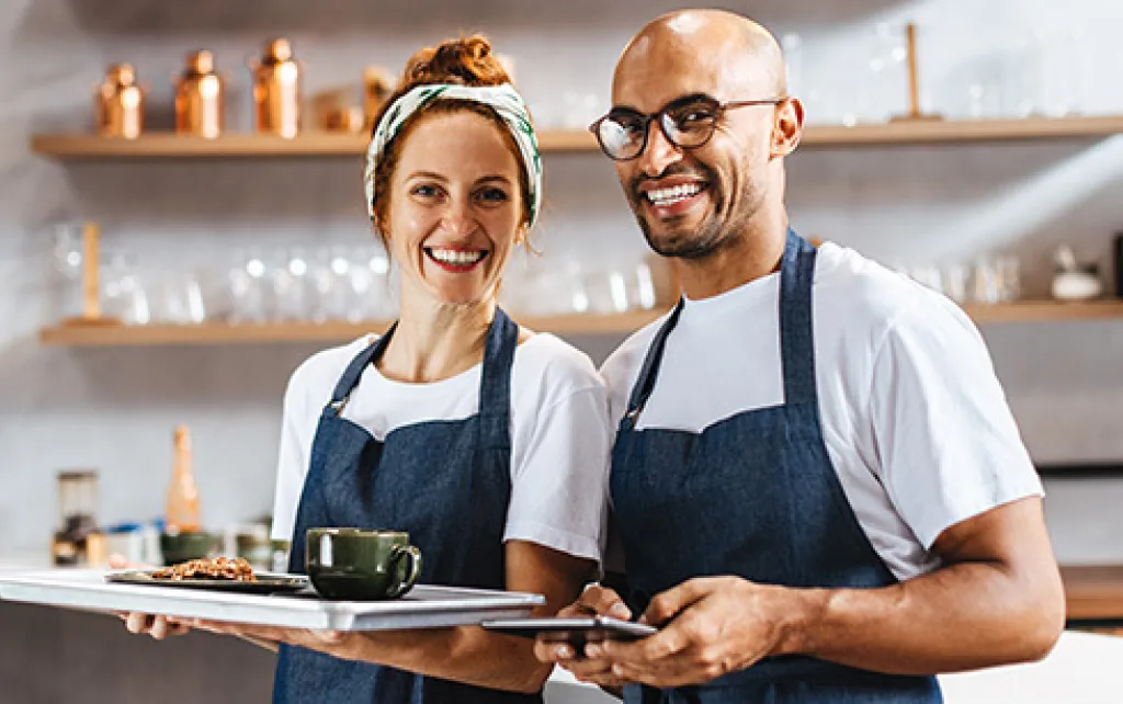 Frau und Mann mit Schürze und Tablett