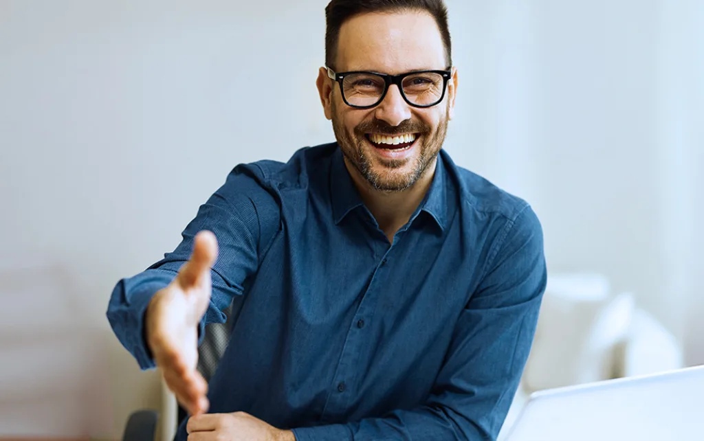 Mann mit Brille reicht die Hand zum Schütteln