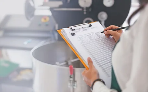 Frau mit Klemmbrett kontrolliert etwas in der Küche