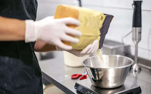 Gewürz wird aus der Verpackung geschüttet und abgewogen