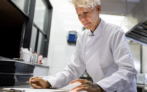 Köchin kontrolliert eine Liste