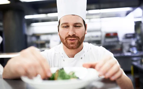 Koch richtet einen Teller an